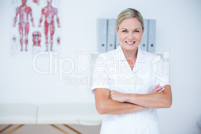 Happy doctor looking at camera with arms crossed