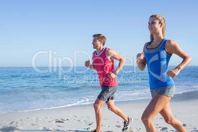 Happy couple running together beside the water