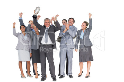 Excited business team cheering at camera with trophy