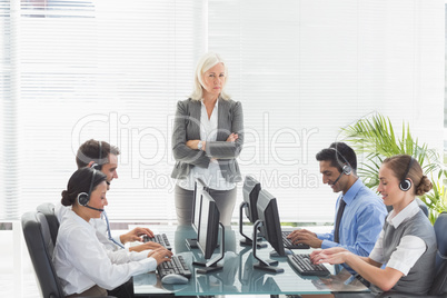 Unhappy businesswoman monitoring her colleagues