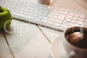 White keyboard and cup of coffee