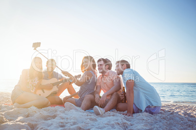 Happy hipsters taking pictures with selfie stick