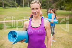 Happy athletic group holding mat