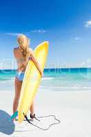 Pretty blonde woman holding surf board