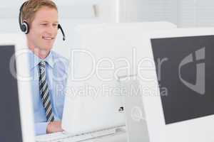 Handsome agent with headset typing on keyboard