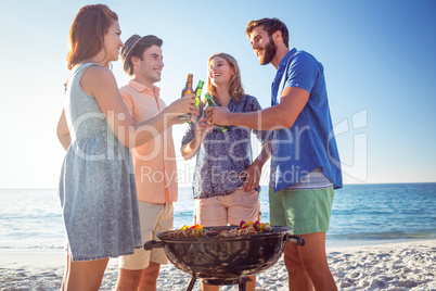 Happy friends doing barbecue and drinking beer