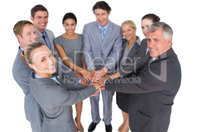 Smiling business team standing in circle hands together