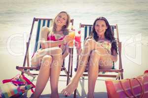 Cute friends having cocktails on the beach