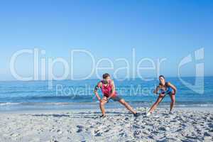 Happy couple stretching together beside the water