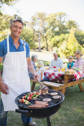 Happy man doing barbecue for his family