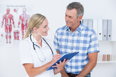 Doctor showing clipboard to her patient