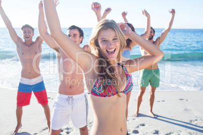 Happy friends dancing on the sand