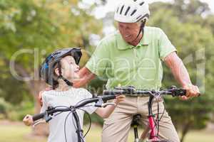 Happy grandfather with his granddaughter on their bike