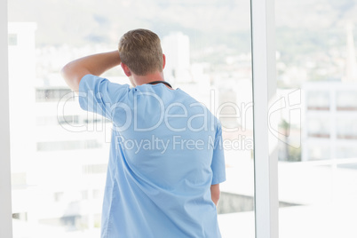 Male doctor looking through windows