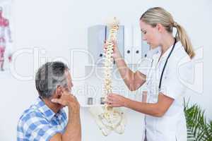 Doctor showing her patient a spine model