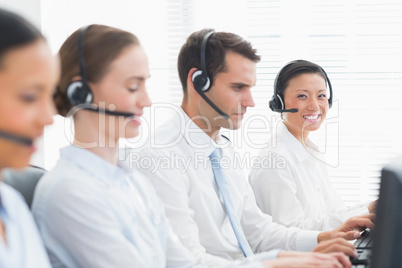 Business people with headsets using computers