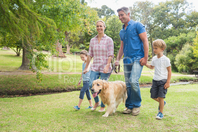 Happy family in the park with their dog