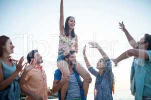 Happy friends dancing on the sand