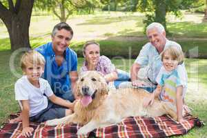 Happy family smiling at the camera with their dog