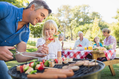 Happy father doing barbecue with her daughter