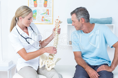 Doctor showing her patient a spine model