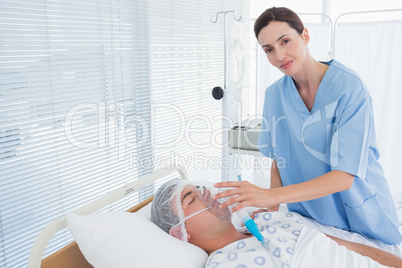 Smiling doctor holding patients oxygen mask