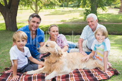 Happy family smiling at the camera with their dog