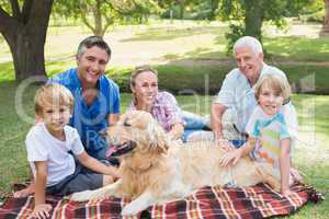 Happy family smiling at the camera with their dog