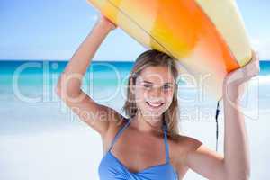 Pretty blonde woman holding surf board