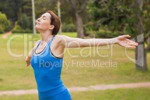 Pretty  brunette stretching her arms during jogging