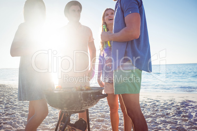 Happy friends doing barbecue and drinking beer