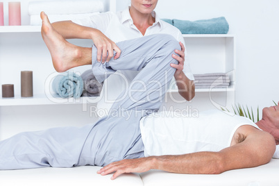 Physiotherapist doing leg massage to her patient