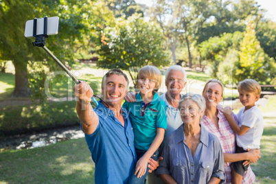 Happy family using a selfie stick in the park