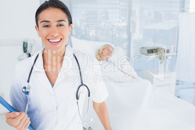 Smiling doctor looking at camera in patients room