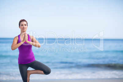 Brunette doing yoga on exercise mat