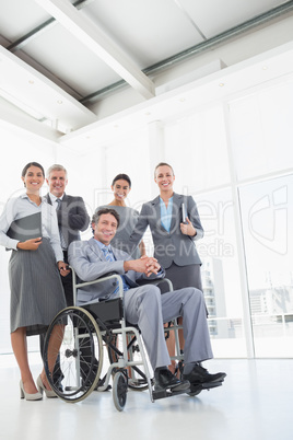 Disabled businessman with his colleagues smiling at camera