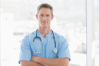 Confident male doctor looking at camera with arms crossed