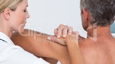 Doctor examining her patient shoulder