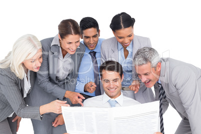 happy business people looking at newspaper