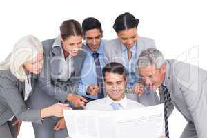 happy business people looking at newspaper