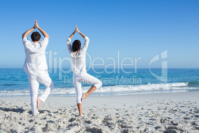 Happy couple doing yoga beside the water Happy couple doing yoga beside the water