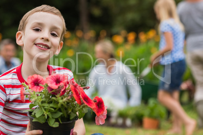 Young boy sitting with flower pot