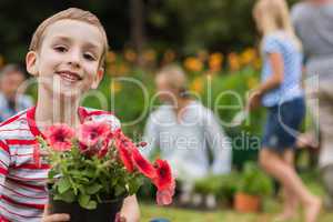 Young boy sitting with flower pot