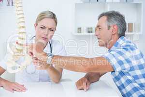 Doctor showing her patient a spine model