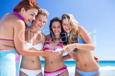 Happy friends looking at smartphone