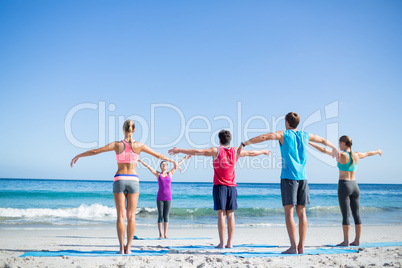 Friends doing yoga together with their teacher