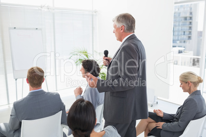 Businessman talking in microphone during conference