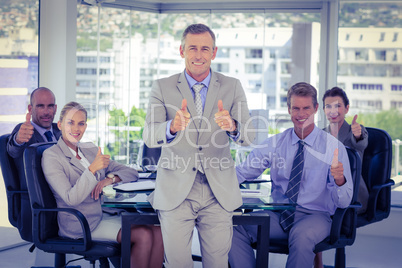 Business team showing thumbs up