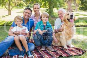 Happy family smiling at the camera with their dog