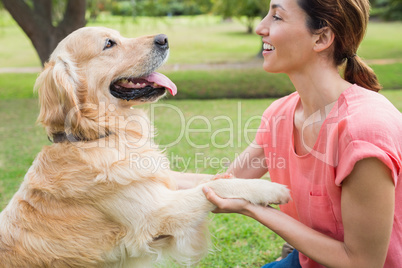 Pretty brunette playing with her dog in the park
